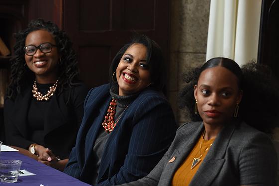 Photo of three women at an event, seated and smiling